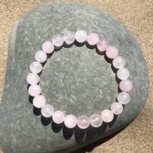 Rose Quartz Bracelet on a pebble by the ocean.
