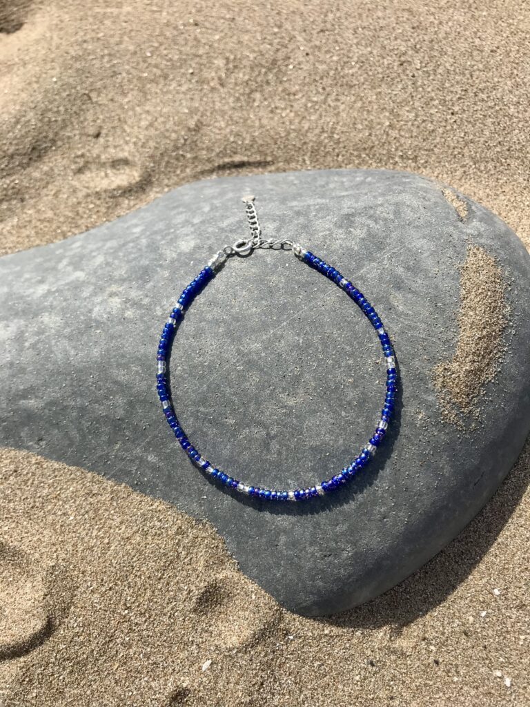 Cobalt beaded bracelet on the beach.