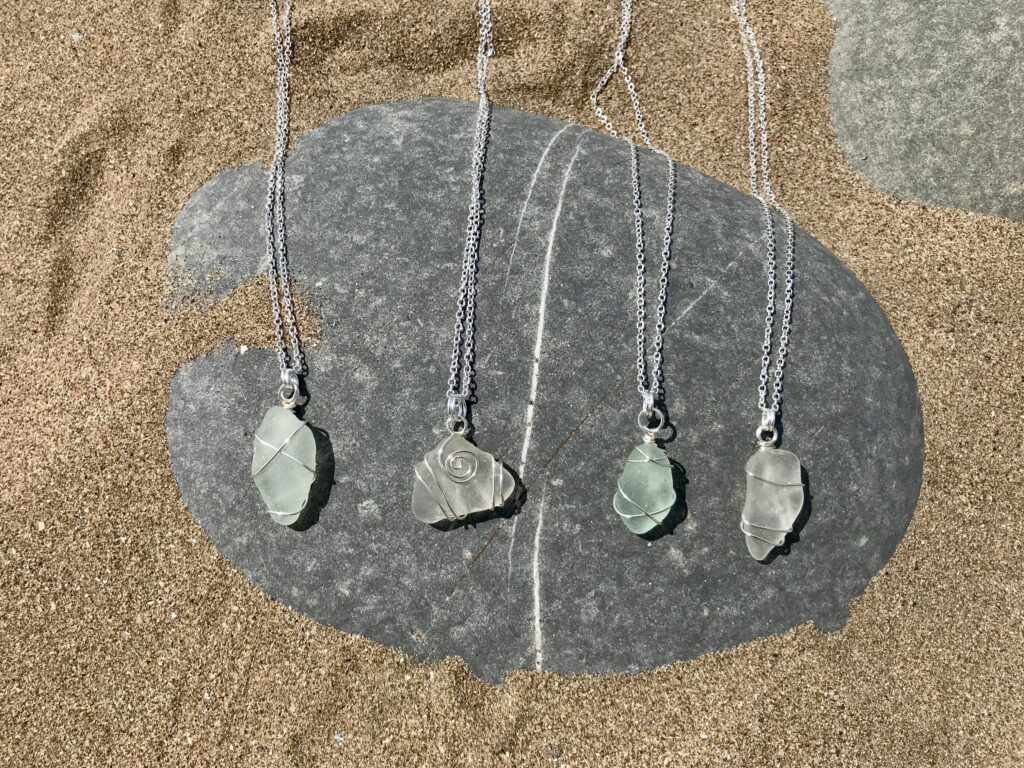 Sea Glass Necklaces laid out one the beach.