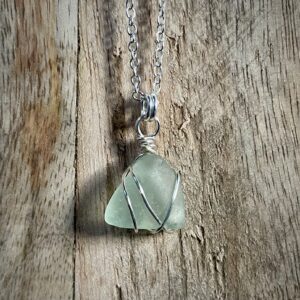 North Coast Sea Glass Necklace displayed on a wooden board.