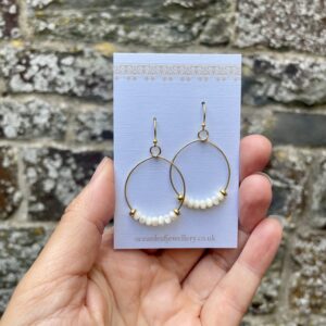 Mother of pearl gold hoop earrings on Ocean Leaf Jewellery display card.